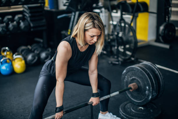 istock Woman body builder exercising with weights in gym 1248493174