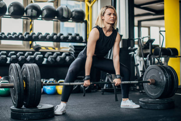 istock Woman body builder exercising with weights in gym 1248493259