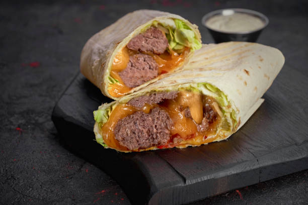 istock Wrap with beef, vegetables and sauce isolated on dark  background 1248498756
