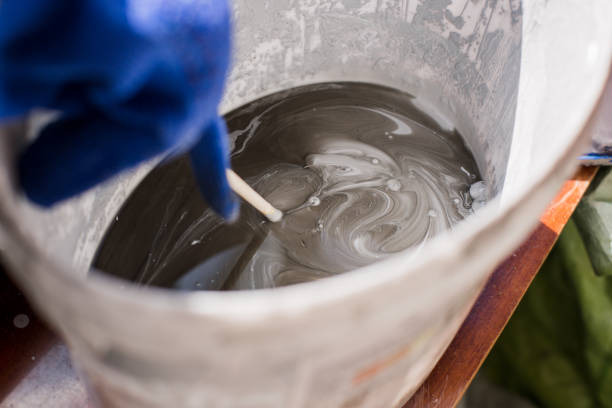 istock stir the paint with the gloved hand of the painter 1248500010