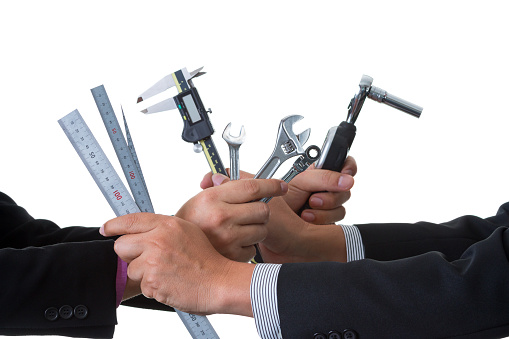 Two mechanical engineers in suit holding many tools and measurement equipment in their hands  with clipping path