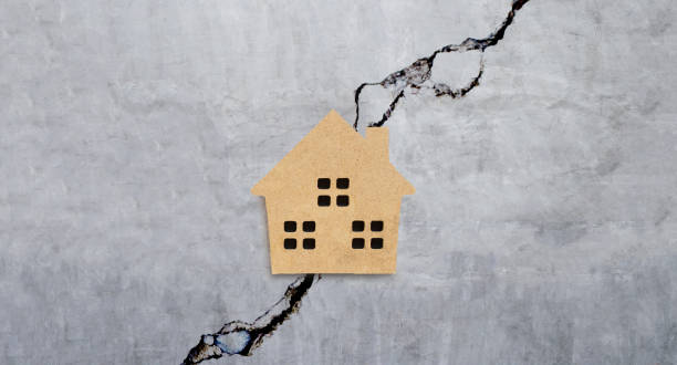 istock Miniature house on cracked cement wall texture background. 1248504127