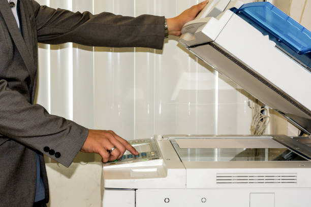 istock Bussiness man Hand press button on panel of printer, printer scanner laser office copy machine supplies start concept. 1248506731