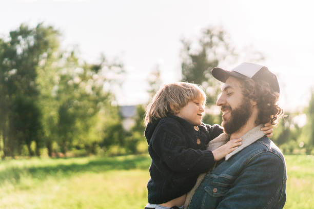 istock Young Caucasian man embracing and holding boy on hands  in summer 1248509903