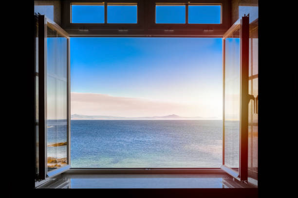 istock view from a dark room to the sea through an open window 1248510047