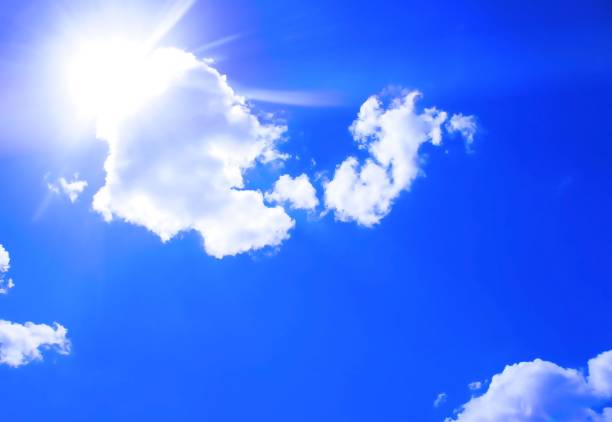 istock Beautiful sunrays shinning through clouds in bright blue sky 1248510380