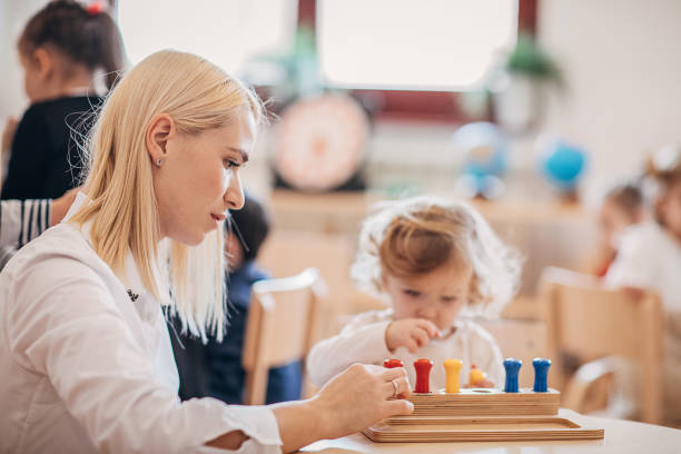 istock Preschool teacher playing with child in classroom 1248510729