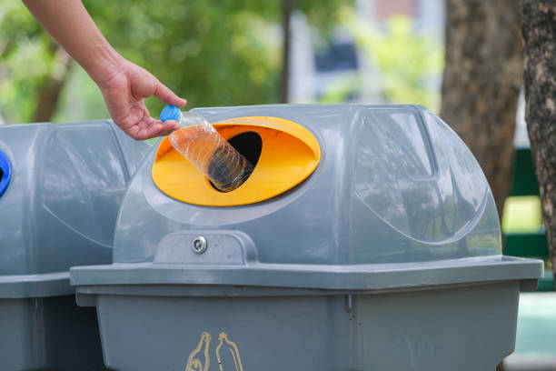 istock Male hand put used bottle in recycle bin 1248511510