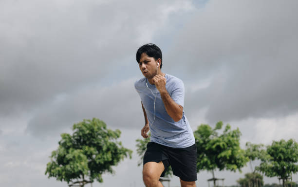 istock young asian man running outdoors in park 1248514078