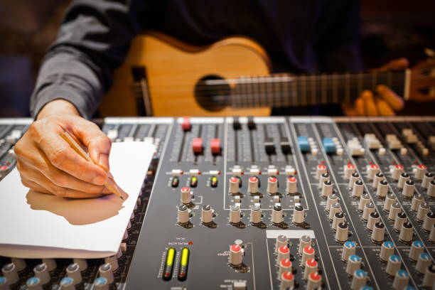 le compositeur masculin mains écrivant une chanson sur le papier blanc dans le studio d’enregistrement - lyricist photos et images de collection