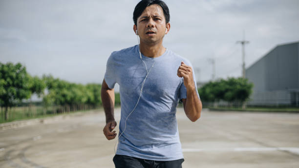 istock young asian man running outdoors in park 1248514395