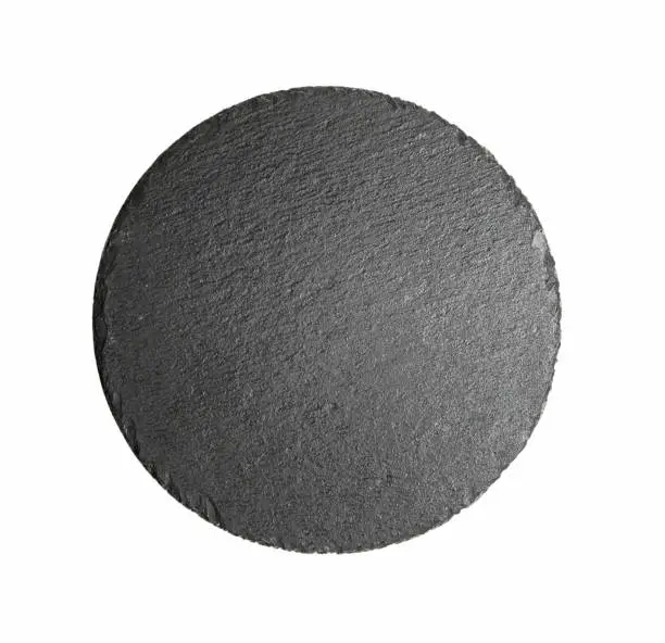 Photo of Round black slate dish plate isolated on white top view.