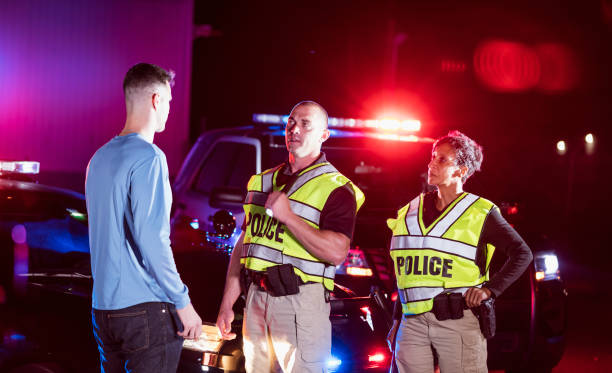 Police officers at night talking with young man