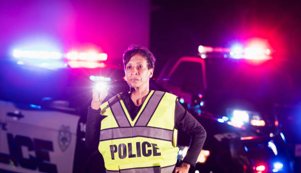 African-American policewoman searching with flashlight