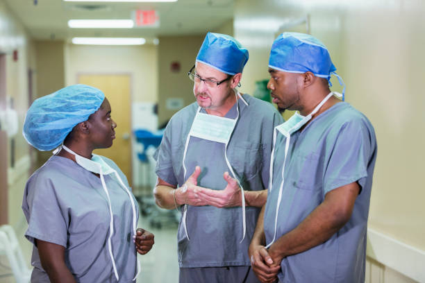 istock Three healthcare workers conversing in hospital corridor 1248524367