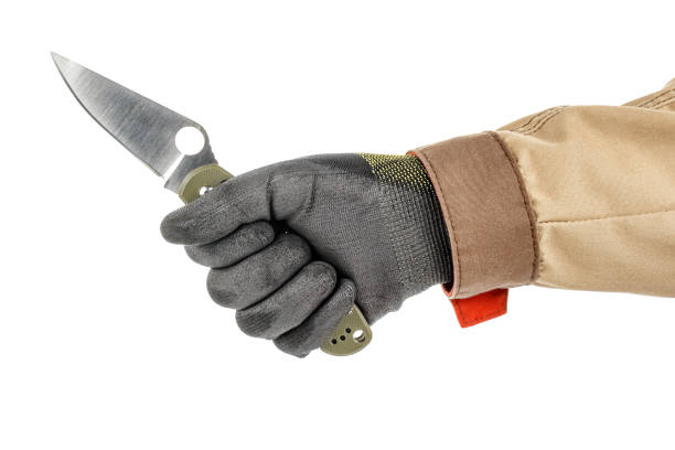 istock Open pocket folding knife with dark green handle in worker hand in black protective glove and brown uniform isolated on white background 1248524600