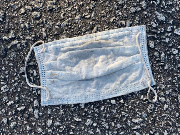 istock Used medical mask laying smashed in a parking lot 1248526215