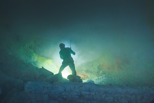 Kawa Ijen Volcano, Banyuwangi, Java Island, Indonesia - July 23 2017 ; Indonesian sulfur miner is carrying sulfur from the floor of the volcano to the valley in the morning at Kawah Ijen volcano Indonesia