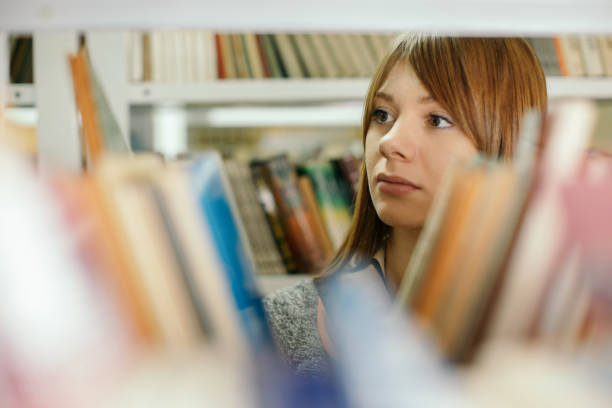 istock Beautiful young woman in library 1248526805