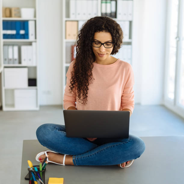 istock Young businesswoman working perched on a desk 1248531254