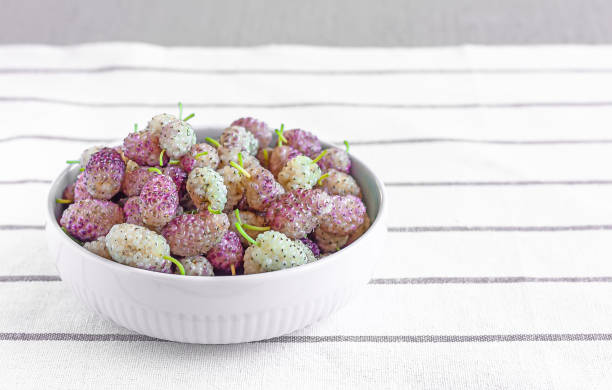 Fresh ripe white mulberries in a ceramic bowl on the table close-up. Selective focus. Space for text. Fresh ripe white mulberries in a ceramic bowl on the table close-up. Selective focus. Space for text. superfruit stock pictures, royalty-free photos & images