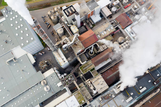 Air pollution from smoke stacks at a paper mill, bird's eye view.