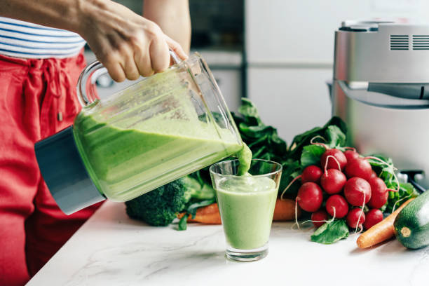 istock woman pours smoothie into a glass 1248537827
