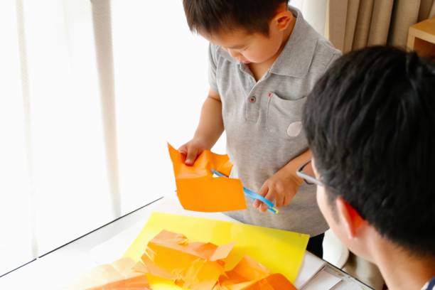 istock Little boy and Father cutting paper 1248540922