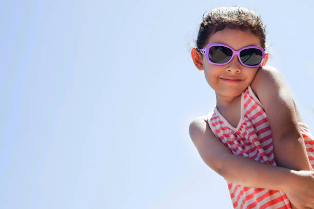 istock Beautiful little girl enjoying the summer using sunglasses while facing camera 1248542166