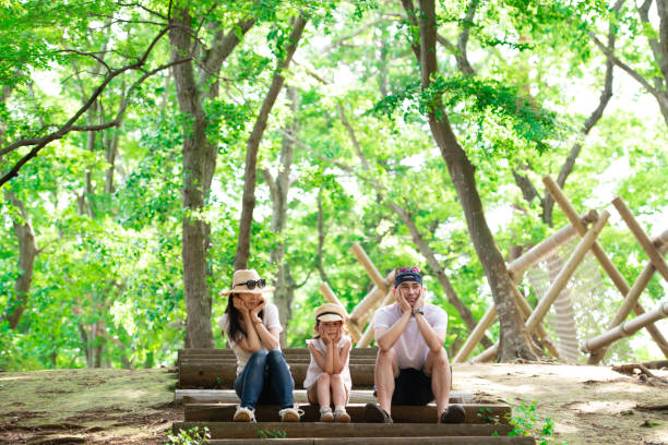 父と母と娘は公園の森に座る - child tree cheerful offspring ストックフォトと画像