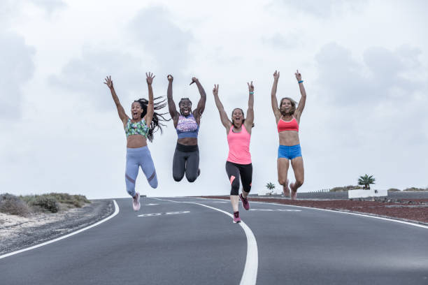 istock Happy diverse sportswomen jumping on road 1248543914