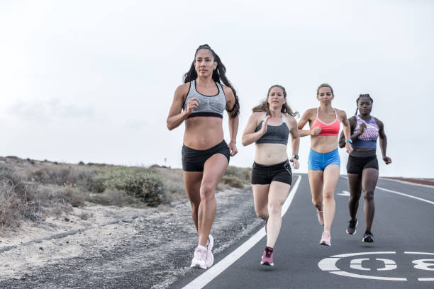 istock Powerful multiracial sportswomen running near roadside 1248544044