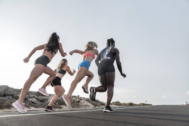 istock Diverse female friends running in evening together 1248544071