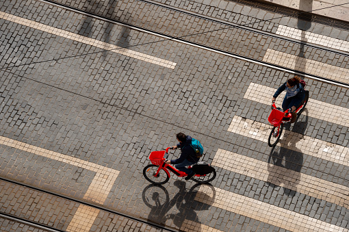Lisbon, Portugal - 2 March 2020:  Top view of two people riding uber jump electric bikes