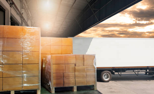 istock Road freight cargo shipment by truck. Large pallet goods waiting for load into caontainer truck at warehouse dock. 1248546305