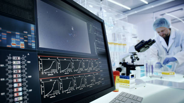 istock Man working on laboratory equipment. DNA research on computer screens 1248549122