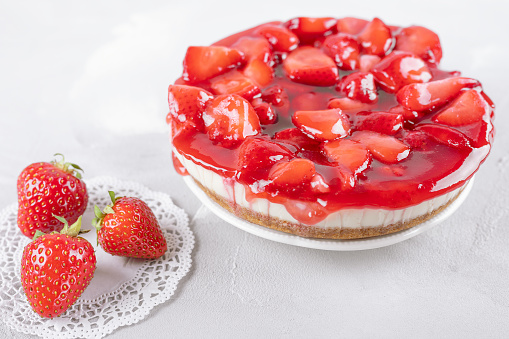 cheesecake with strawberry and fresh berries on gray table, closeup