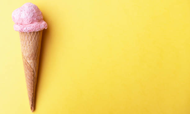 istock Close up strawberry ice cream in waffles cone on yellow background. Copy space. 1248551722