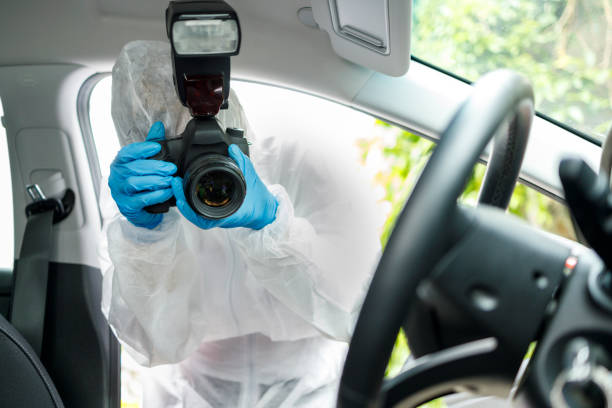 istock Investigator wearing protective full body suit and using camera in a car which is a crime scene 1248555317