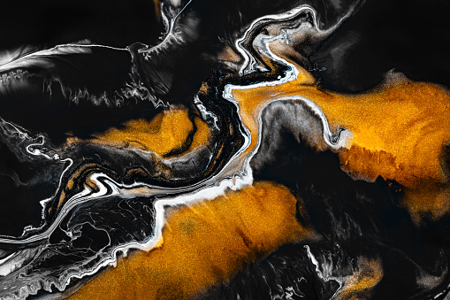 Fluid art texture. Abstract background with mixing paint effect. Liquid acrylic picture with artistic mixed paints. Can be used for baner or wallpaper. Golden, black and gray overflowing colors