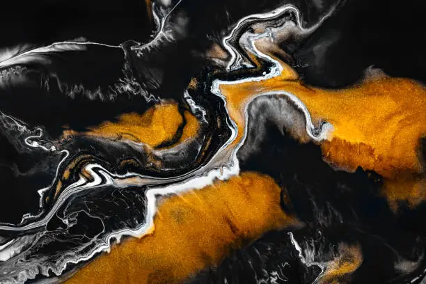 Photo of Fluid art texture. Abstract background with mixing paint effect. Liquid acrylic picture with artistic mixed paints. Can be used for baner or wallpaper. Golden, black and gray overflowing colors.