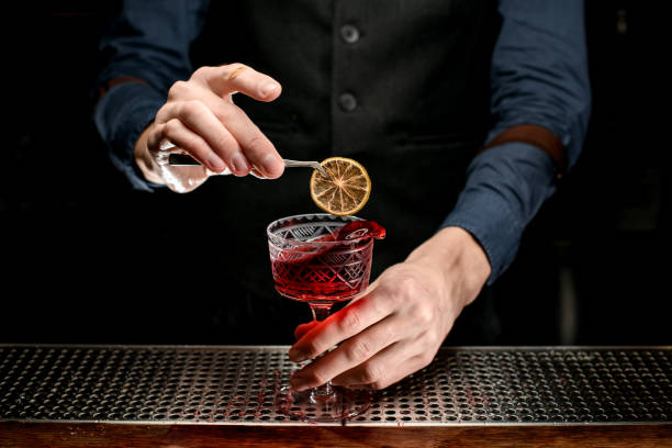 istock bartender decorates transparent glass with splash wine. 1248558198