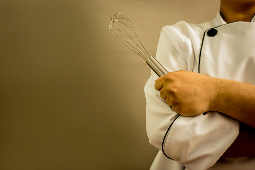 Close up of unrecognizable chef holding whisk - Cooking concepts