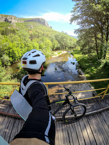 XIAOYIA male mountainbiker is crossing the Nisava River in the Serbia. The river is well known for rafting and kayaking