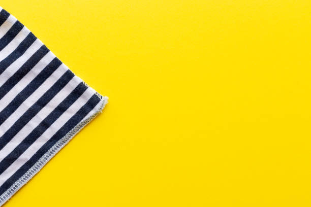 istock Blue and white striped fabric closeup triangle on a bright yellow background. Top view with copy space. Summer concept template for advertising, sales, promotions 1248561452