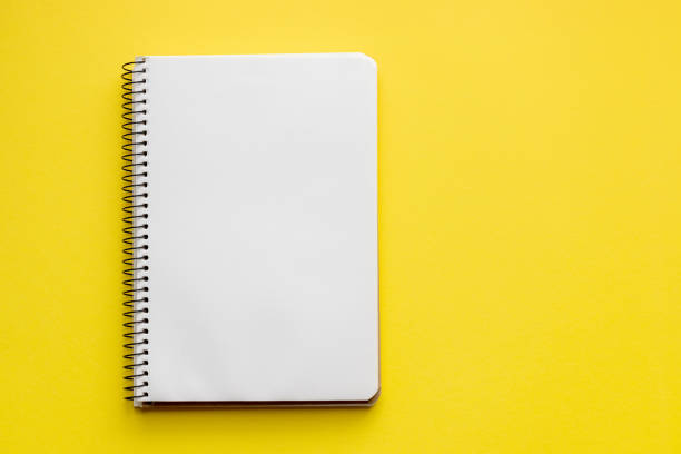 istock Spiral notebook with blank empty white sheets on a bright yellow background, top view, flat lay with copy space 1248561464