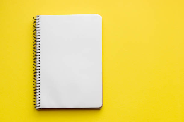Spiral notebook with blank empty white sheets on a bright yellow background, top view, flat lay with copy space Spiral notebook with blank empty white sheets on a bright yellow background, top view, flat lay with copy space note pad stock pictures, royalty-free photos & images