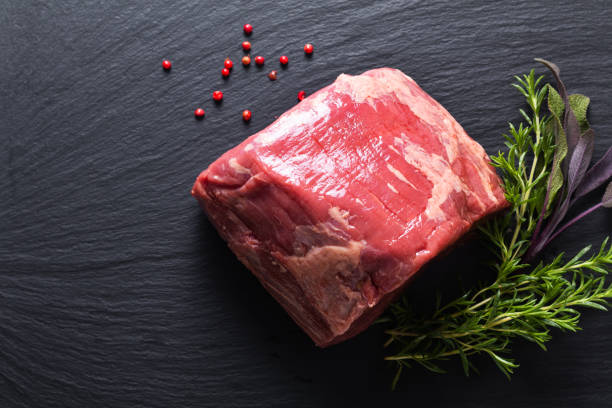 concepto de comida orgánico crudo carne redonda de carne en placa de piedra pizarra negra con espacio de copia - round of beef fotografías e imágenes de stock