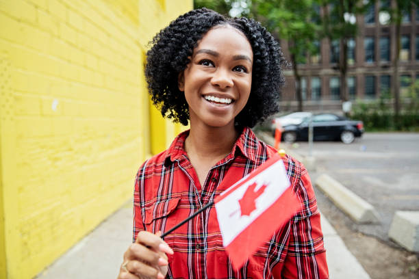 Canada Day Celebration happy smiling black woman with a Canadian flag canada day photos stock pictures, royalty-free photos & images