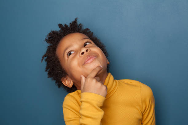 istock Little black child boy thinking on blue background 1248564404